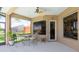 Cozy covered patio with an outdoor dining set, ceiling fan, and serene views of the lush backyard at 280 Dahlia Ct, Bradenton, FL 34212