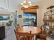 Cozy dining area with a charming wooden table set, large windows offering a gorgeous lake and pool view at 280 Dahlia Ct, Bradenton, FL 34212