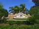 Beautiful stone entrance sign for Greyhawk Landing with lush landscaping and palm trees at 280 Dahlia Ct, Bradenton, FL 34212