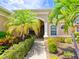 Inviting front entrance showcasing lush tropical landscaping and a charming walkway at 280 Dahlia Ct, Bradenton, FL 34212