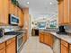 Well-equipped kitchen featuring a stainless steel stove and microwave along with wood cabinetry and a sink overlooking the living room at 280 Dahlia Ct, Bradenton, FL 34212