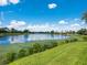 Beautiful lake view featuring lush greenery, calm water reflecting the sky, and scenic lakeside homes at 280 Dahlia Ct, Bradenton, FL 34212