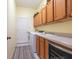 Well-organized laundry room featuring wooden cabinets, modern washer and dryer, complemented by neutral wall color and a white door at 280 Dahlia Ct, Bradenton, FL 34212