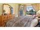 A comfortable main bedroom features a king bed, carpeted floors, plenty of natural light, and a view of the screened patio at 280 Dahlia Ct, Bradenton, FL 34212