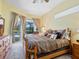 A luxurious main bedroom featuring a king bed, carpeted floor and a sliding glass door leading to the screened patio at 280 Dahlia Ct, Bradenton, FL 34212
