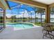 Inviting screened patio featuring a pool with beautiful lake views, creating an idyllic outdoor living space at 280 Dahlia Ct, Bradenton, FL 34212