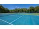 Beautiful tennis court with blue surface, white lines, green fence, and net for recreational sports at 280 Dahlia Ct, Bradenton, FL 34212