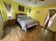 This bedroom has bright yellow walls, a queen-sized bed, tile floor, and a door to the outside at 3918 Wake Ave, Sarasota, FL 34241