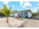 Stylish home with a light blue exterior, white garage door, and vibrant purple door and shutter accents at 441 62Nd St, Holmes Beach, FL 34217