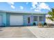 Charming home with a light blue exterior, white garage door, and vibrant purple door and shutter accents at 441 62Nd St, Holmes Beach, FL 34217