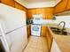 Bright kitchen featuring wooden cabinets, white appliances, and neutral tile flooring at 5238 Sunridge Palms Dr, Tampa, FL 33617