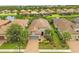 Aerial view of a single-story home with tile roof, surrounded by landscaped yard and serene community lakes at 5596 Cantucci St, Nokomis, FL 34275