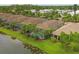Aerial view of homes with screened pools, surrounded by lush landscaping and a serene lake at 5596 Cantucci St, Nokomis, FL 34275