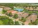 Aerial view of beautiful single Gathering homes with paved driveways, lush landscaping and a beautiful lake nearby at 5596 Cantucci St, Nokomis, FL 34275