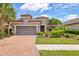 Beautiful single-story home featuring a paver driveway, two-car garage, tile roof and lush tropical landscaping at 5596 Cantucci St, Nokomis, FL 34275