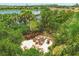 Cozy outdoor fire pit area with comfortable seating, surrounded by lush landscaping and a tranquil lake view at 5596 Cantucci St, Nokomis, FL 34275