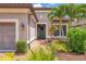 Close up view of the front of a home featuring a welcoming front door and lush tropical landscaping at 5596 Cantucci St, Nokomis, FL 34275