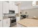 Open-concept kitchen with stainless steel appliances and adjacent dining area at 5596 Cantucci St, Nokomis, FL 34275