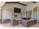 Inviting covered patio area with stone fireplace, TV, and comfortable seating, perfect for relaxing and entertaining outdoors at 5596 Cantucci St, Nokomis, FL 34275