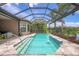 Private pool with waterfall feature, screened enclosure, and lush landscaping, offering a relaxing outdoor oasis at 5596 Cantucci St, Nokomis, FL 34275