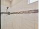 Modern shower featuring white marble tiling with a decorative accent, built-in seat, and a shower niche at 5596 Cantucci St, Nokomis, FL 34275