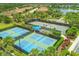 Aerial view of community tennis and pickleball courts surrounded by lush landscaping and residential neighborhood at 5596 Cantucci St, Nokomis, FL 34275