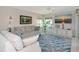 Bright living room features sofas with decorative pillows, a ceiling fan, and a flat-screen TV at 719 Estuary Dr # 719, Bradenton, FL 34209