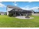Landscaped backyard featuring a screened-in pool and a brick fire pit area with comfortable seating, perfect for outdoor gatherings at 731 116Th Ne Ct, Bradenton, FL 34212