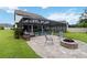 Beautiful backyard featuring a screened-in pool, stone firepit area and plenty of green space at 731 116Th Ne Ct, Bradenton, FL 34212