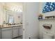 Bathroom shows the vanity with granite countertop and decorative shelf with decorations and toilet at 731 116Th Ne Ct, Bradenton, FL 34212