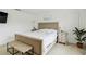 Bedroom view featuring a stylish bed and bench, complimented with side tables, lamps, and a bright window at 731 116Th Ne Ct, Bradenton, FL 34212