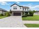 Beautiful two-story home with a stone facade and a well-maintained lawn and a brick driveway at 731 116Th Ne Ct, Bradenton, FL 34212