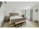 Bedroom with stylish bed and bench, complimented with side tables, lamps, and a bright window at 731 116Th Ne Ct, Bradenton, FL 34212