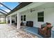 Covered outdoor patio with comfortable seating, ceiling fan, and brick pavers, creating an inviting space for relaxation at 731 116Th Ne Ct, Bradenton, FL 34212