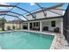 Expansive screened-in pool with brick paver deck, outdoor seating, and a view of the home's rear elevation at 731 116Th Ne Ct, Bradenton, FL 34212