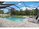 Beautiful screened-in pool with lounge chairs, lush green backyard view, and brick paver surround for outdoor enjoyment at 731 116Th Ne Ct, Bradenton, FL 34212