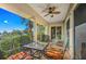 Comfortable balcony with a ceiling fan offering beautiful views of tropical trees and blue skies at 7324 Gulf Dr # 12, Holmes Beach, FL 34217