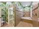 A well lit bathroom featuring a soaking tub, tiled shower and adjacent walk-in closet at 7324 Gulf Dr # 12, Holmes Beach, FL 34217