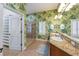 Bathroom boasts a walk-in shower, dual sinks, leafy wallpaper and adjacent walk-in closet at 7324 Gulf Dr # 12, Holmes Beach, FL 34217