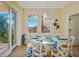 Elegant dining area with glass table, chandelier, and scenic outdoor views at 7324 Gulf Dr # 12, Holmes Beach, FL 34217