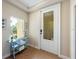 Lovely entryway with decorative door and sidelight window, table with blue towels, and tile flooring at 7324 Gulf Dr # 12, Holmes Beach, FL 34217