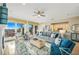 Bright living room with tan tile, ceiling fan, blue and beige furniture, and access to balcony at 7324 Gulf Dr # 12, Holmes Beach, FL 34217
