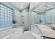 Bright bathroom features dual vanity, soaking tub, and shower with a tiled floor and large mirror at 7904 Hampton Ct, University Park, FL 34201
