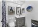 Neutral bathroom features a vanity, artwork, and toilet with a tiled floor at 7904 Hampton Ct, University Park, FL 34201