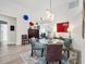 Chic dining area with a glass table, modern chairs, decorative wall art, and hardwood flooring at 7904 Hampton Ct, University Park, FL 34201