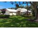 Beautiful single-story home featuring a well-manicured lawn, mature trees, and lush landscaping at 7904 Hampton Ct, University Park, FL 34201