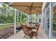Covered patio with wooden table and chairs, umbrella, and grill for outdoor dining at 7904 Hampton Ct, University Park, FL 34201