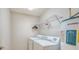 This laundry room features a washer and dryer, overhead shelving for storage, and a water heater at 8823 White Sage Loop # 1802, Lakewood Ranch, FL 34202