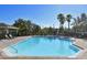 Community pool with clear blue water, palm trees, and ample seating for relaxation and recreation at 8823 White Sage Loop # 1802, Lakewood Ranch, FL 34202