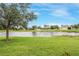 Lush backyard featuring a tranquil pond, green grass, and scenic views of surrounding homes at 2819 47Th E St, Palmetto, FL 34221